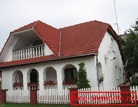 Casa blanca con techo de tejas rojas.
