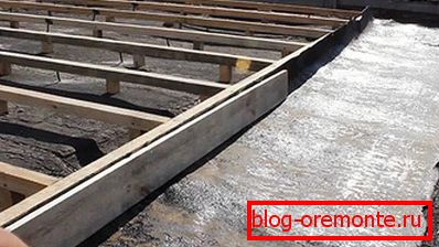 Caja de madera para pizarra sobre una base de hormigón.