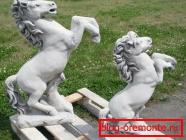 Foto amateur de estatuas terminadas en forma de caballos, que están hechas de hormigón.