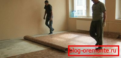 Foto amateur, el proceso de colocación de linóleo en el piso de concreto.