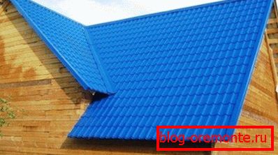 En esta foto de una casa en forma de barra, el azulejo de metal de un esquema de colores brillantes sirve como un piso para techos. En esta foto de una casa en forma de barra, el azulejo de metal de un esquema de colores brillantes sirve como un piso para techos.