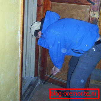 Desmantelando la puerta vieja Instalación de puerta de entrada metálica.